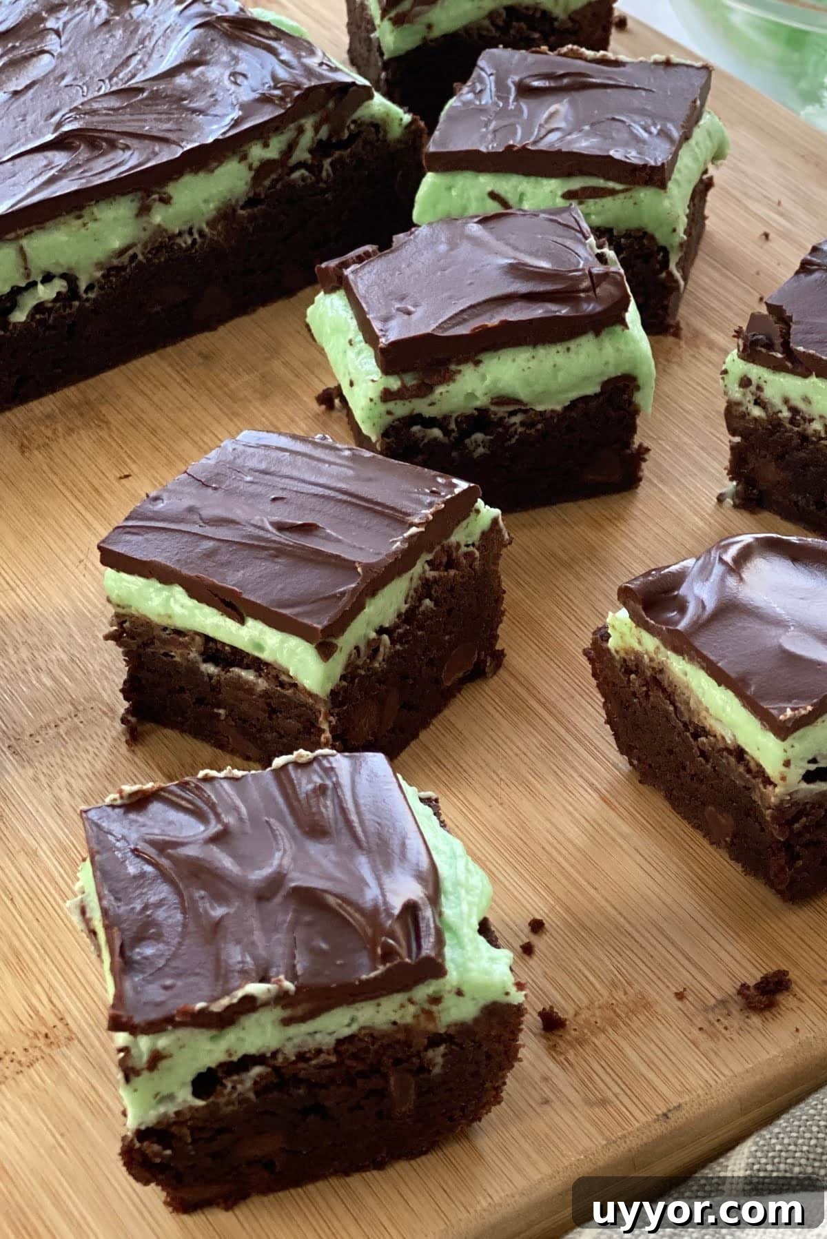 Decadent Fudgy Mint Brownies Recipe 2 Mint brownies on a cutting board.