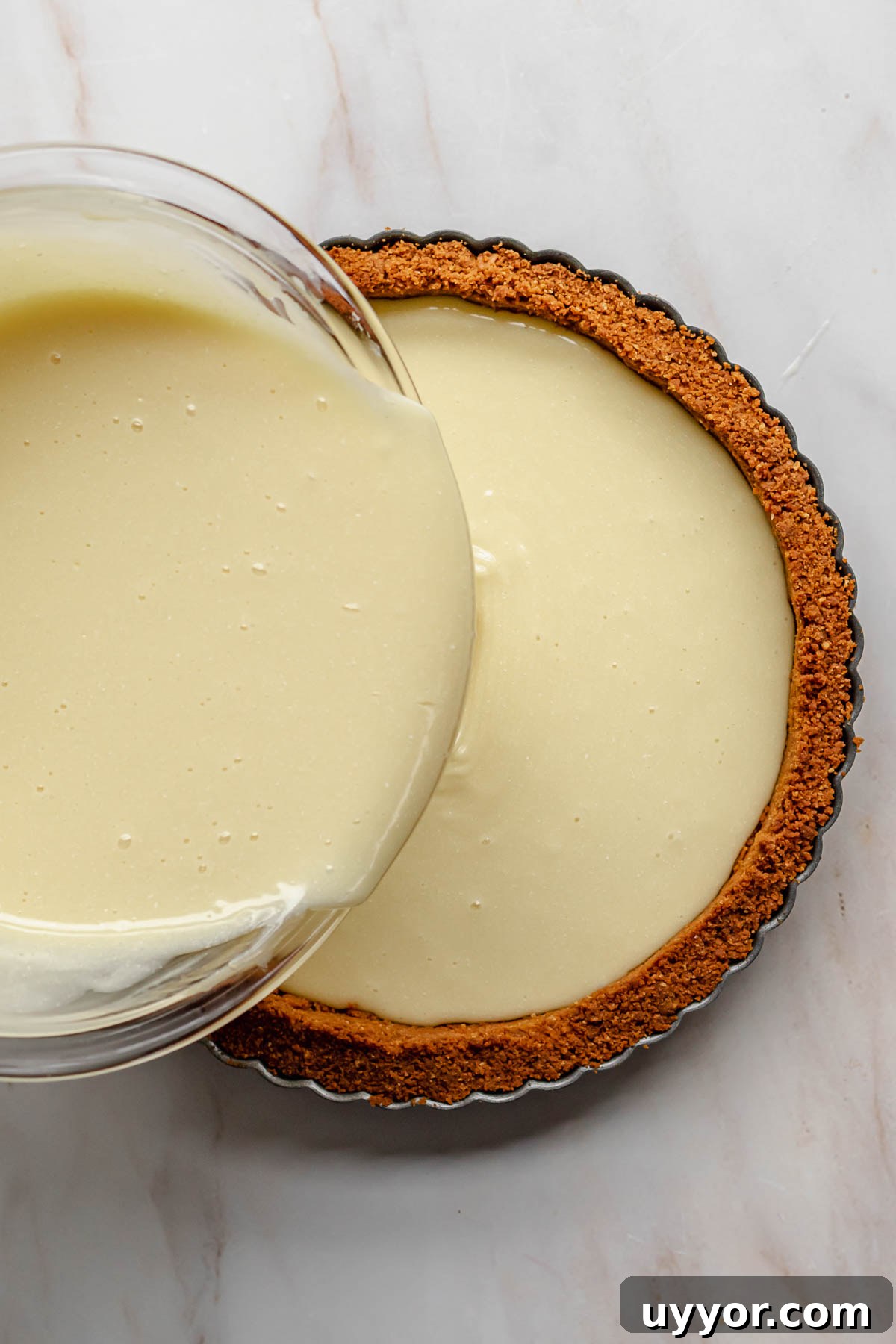 Pouring white chocolate ganache into the tart pan.