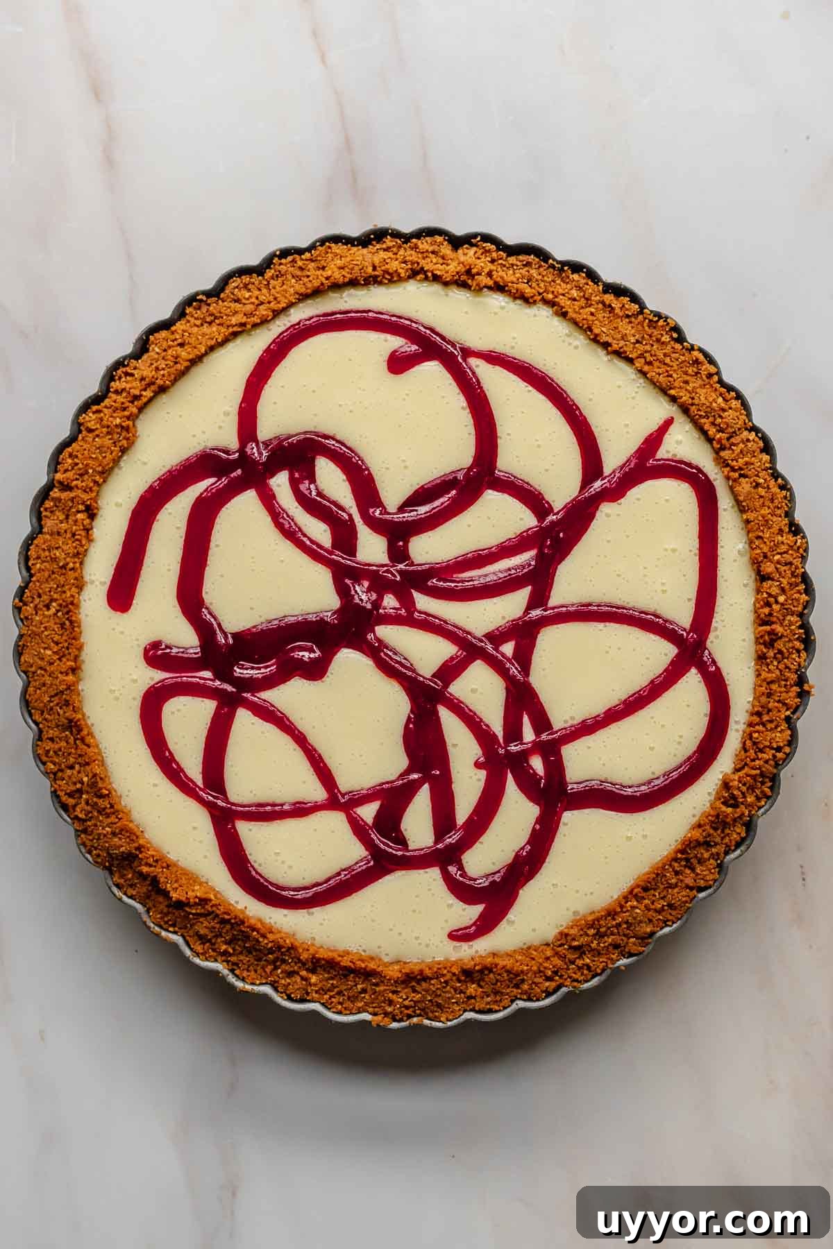 Cranberry swirls piped into the top of white chocolate tart.