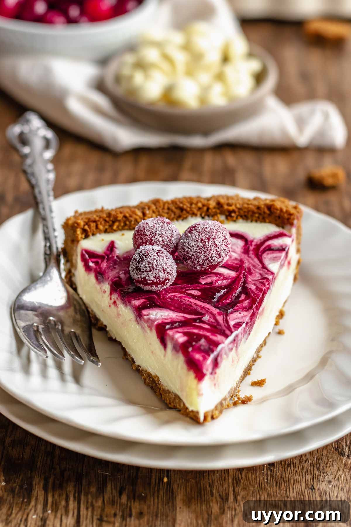A slice of white chocolate tart on a plate with a fork next to it.