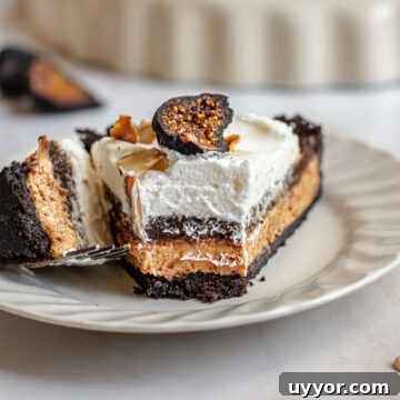 Slice of fig tart with the front bite removed on a fork.
