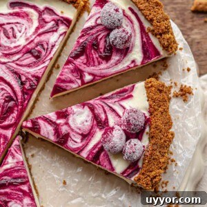 Slices of white chocolate tart topped with sugared cranberries on a serving platter.