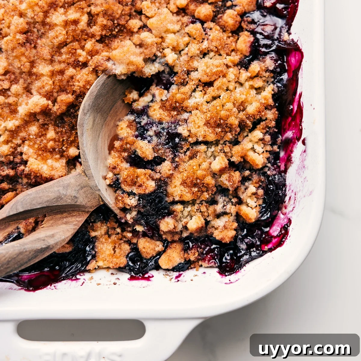 My Favorite Blueberry Cobbler Recipe Freshly baked blueberry cobbler with a spoonful being served from the dish.