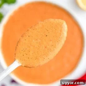 A spoonful of peri peri sauce over a bowl.
