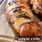Grilled Asian Pork Tenderloin cut into slices on cutting board.