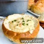 San Francisco Clam Chowder in a bread bowl on a white plate.