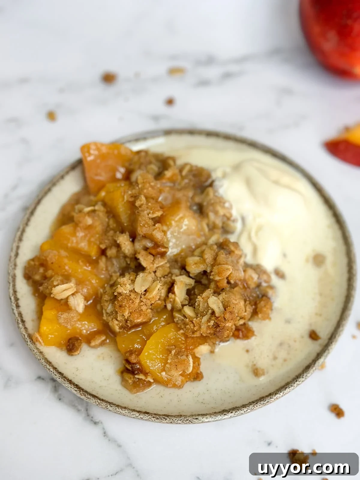 Brown Butter Peach Crisp Recipe — Warm Summer Dessert 2 brown butter peach crisp on a plate with vanilla ice cream.