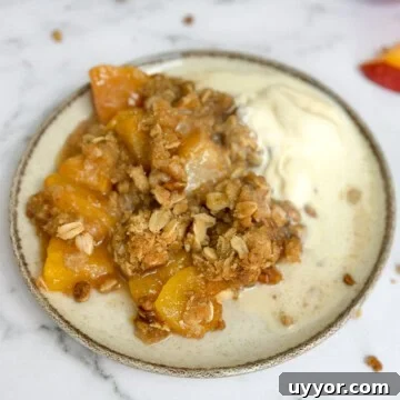 Brown Butter Peach Crisp Recipe — Warm Summer Dessert 17 brown butter peach crisp on a plate with vanilla ice cream