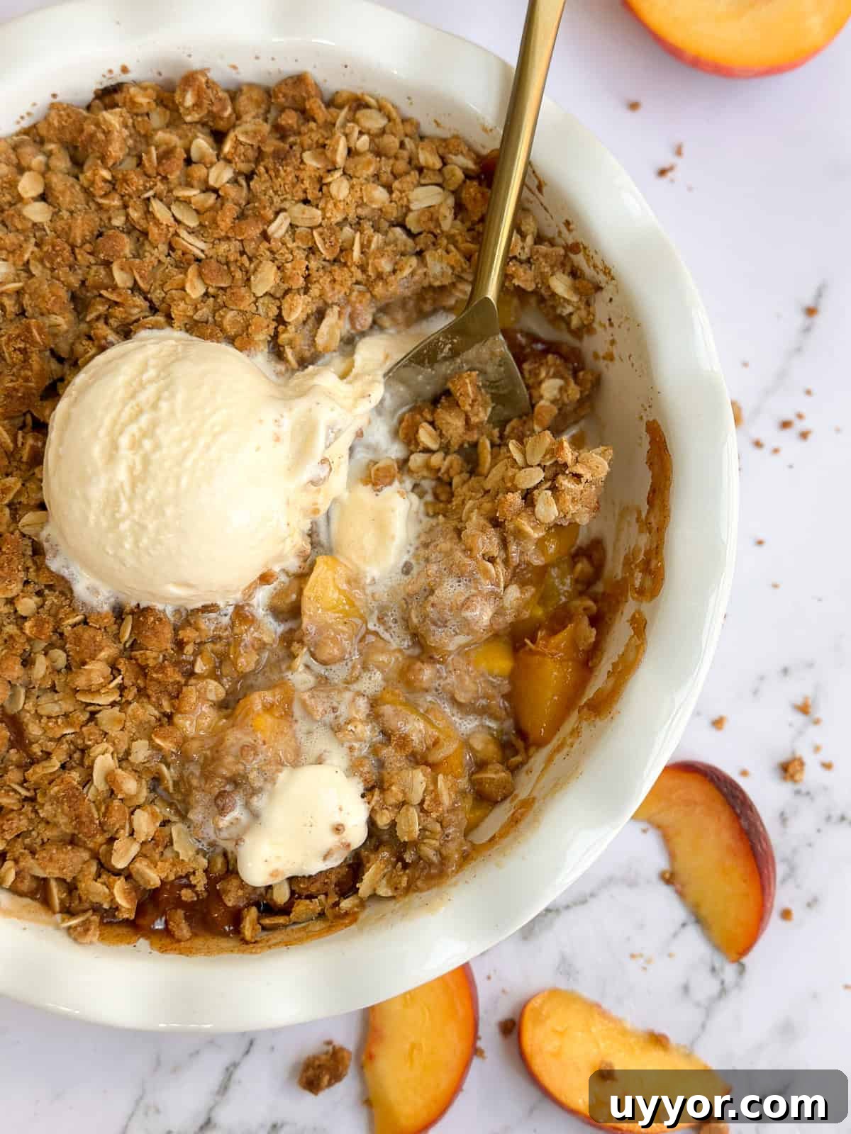 Brown Butter Peach Crisp Recipe — Warm Summer Dessert 3 a large spoon dished into the whole brown butter peach crisp.