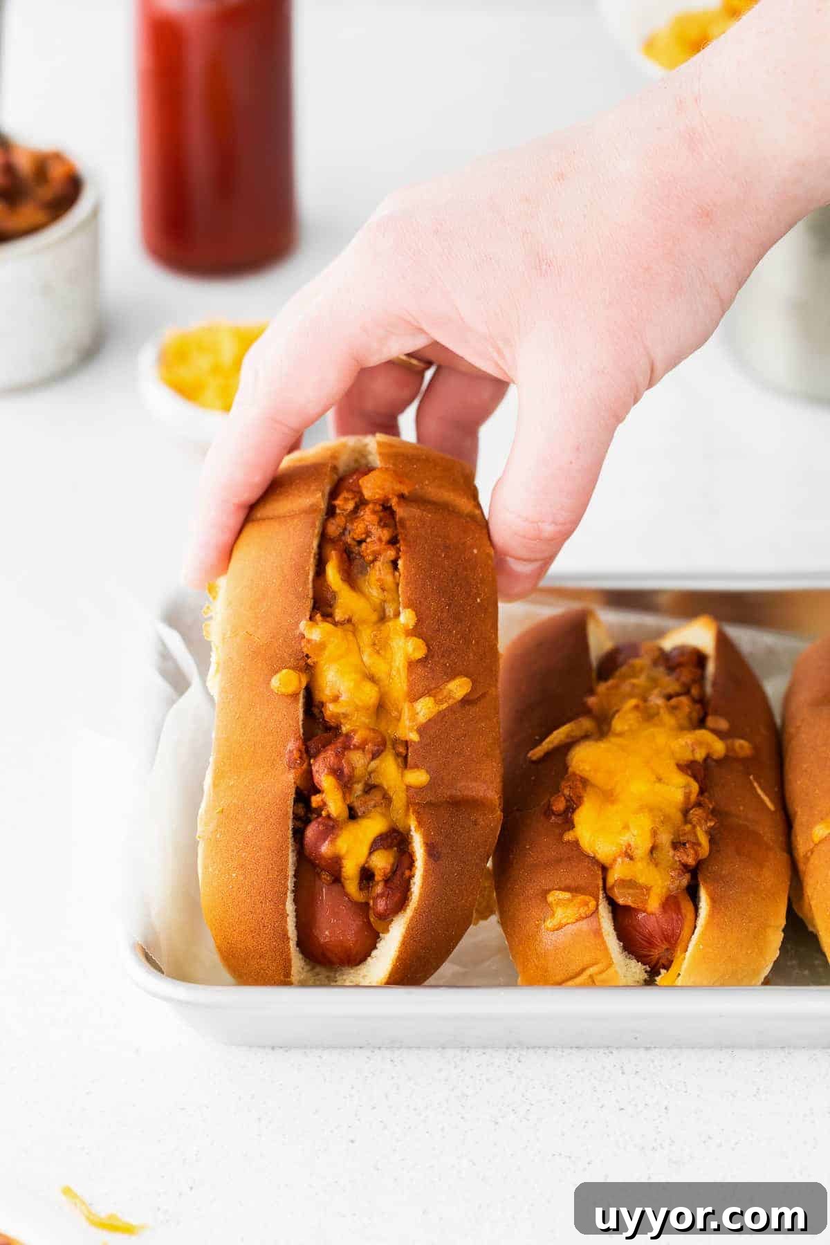 Chili cheese dog Hand holding chili cheese dog.