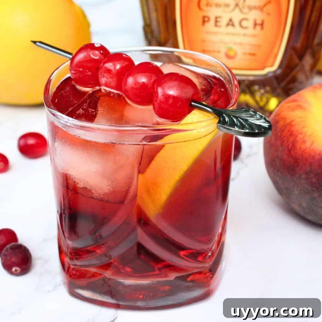 A red crown royal flush cocktail garnished with maraschino cherries.