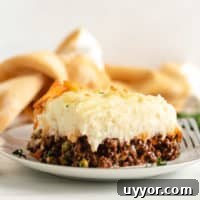 Mashed potatoes on meat filling on a white plate.