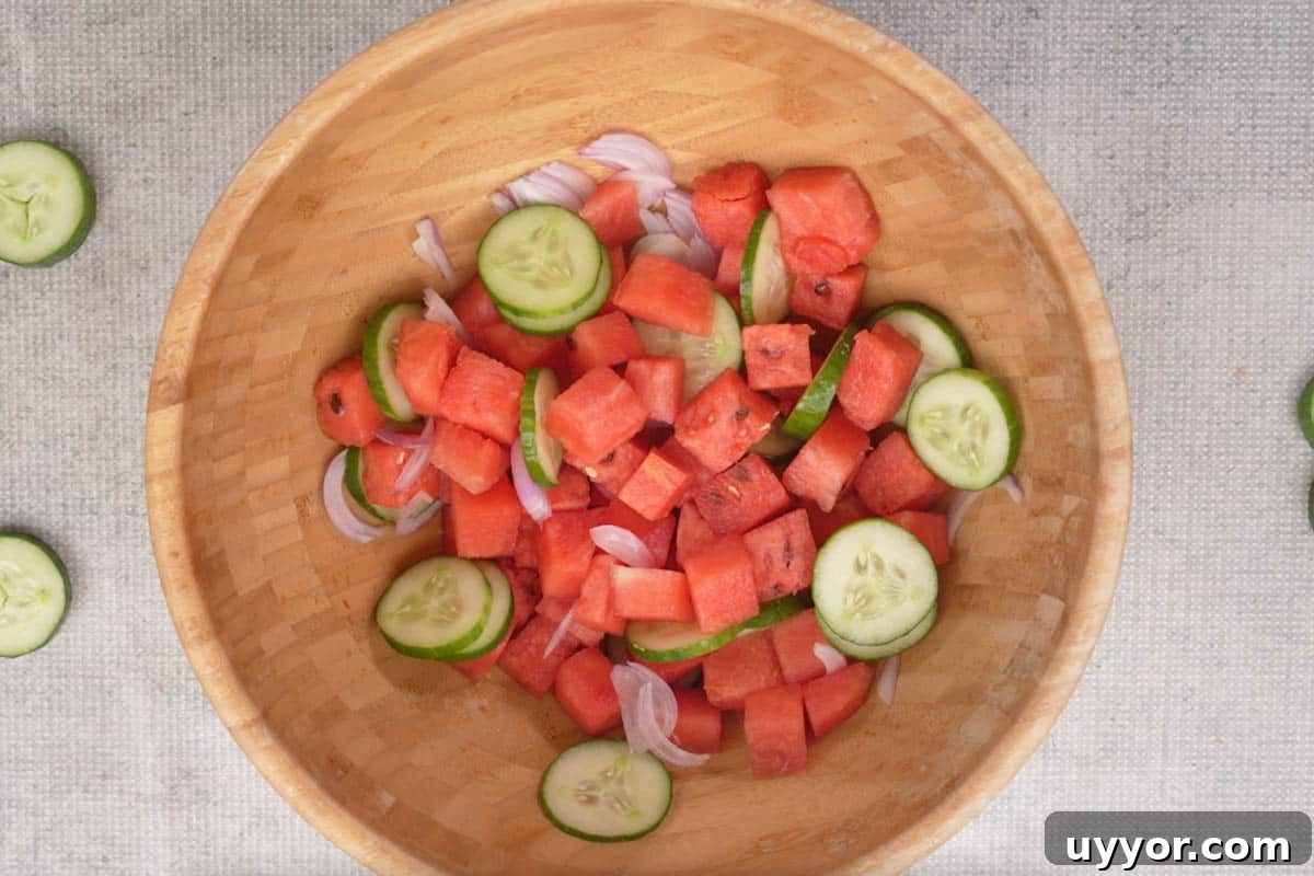 Authentic Thai Watermelon Salad Recipe for Summer Flavor 4 Watermelon, cucumber and onions mixed in a bowl.