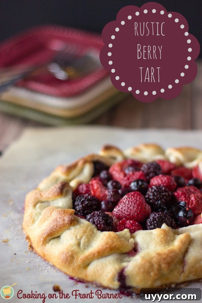 Rustic Berry Tart is a great way to use seasonal berries! You can make your own pie crust from scratch or keep it simple with a pre-made crust from the store! angled view of rustic berry tart on parchment paper
