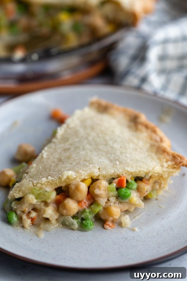 Hearty Chickpea Pot Pie (Vegan Comfort Dish) 3 slice of pot pie on a plate with chickpeas and veggies spilling out