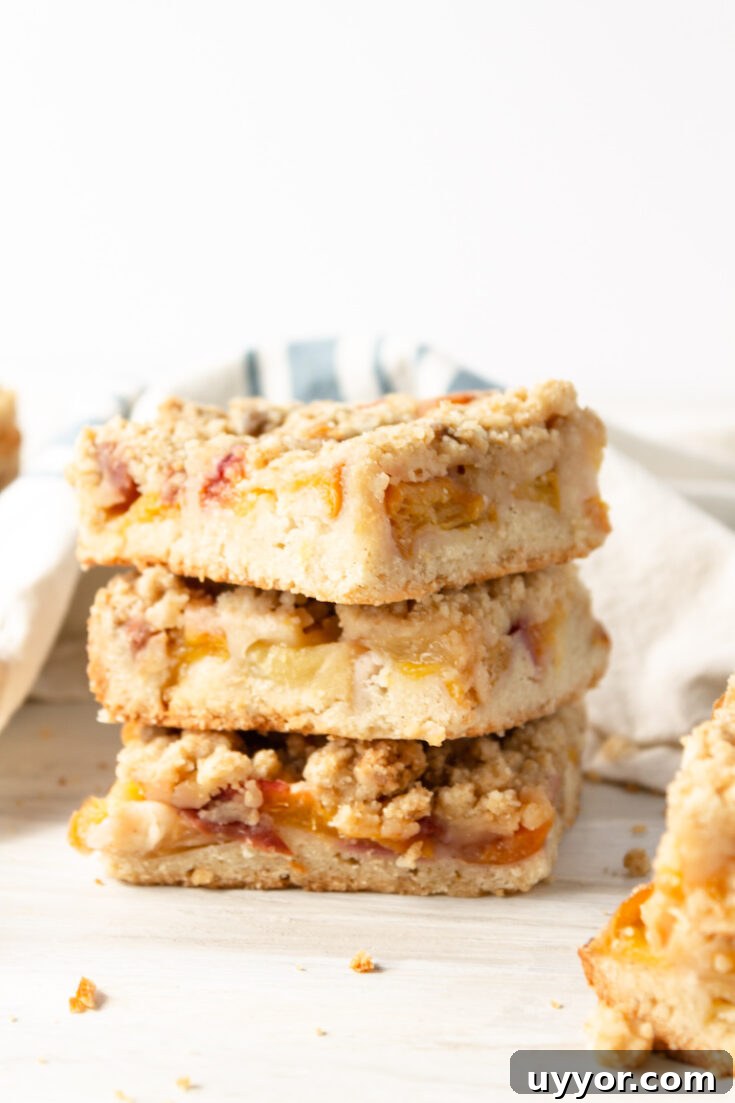three peach crumb bars stacked on top of each other