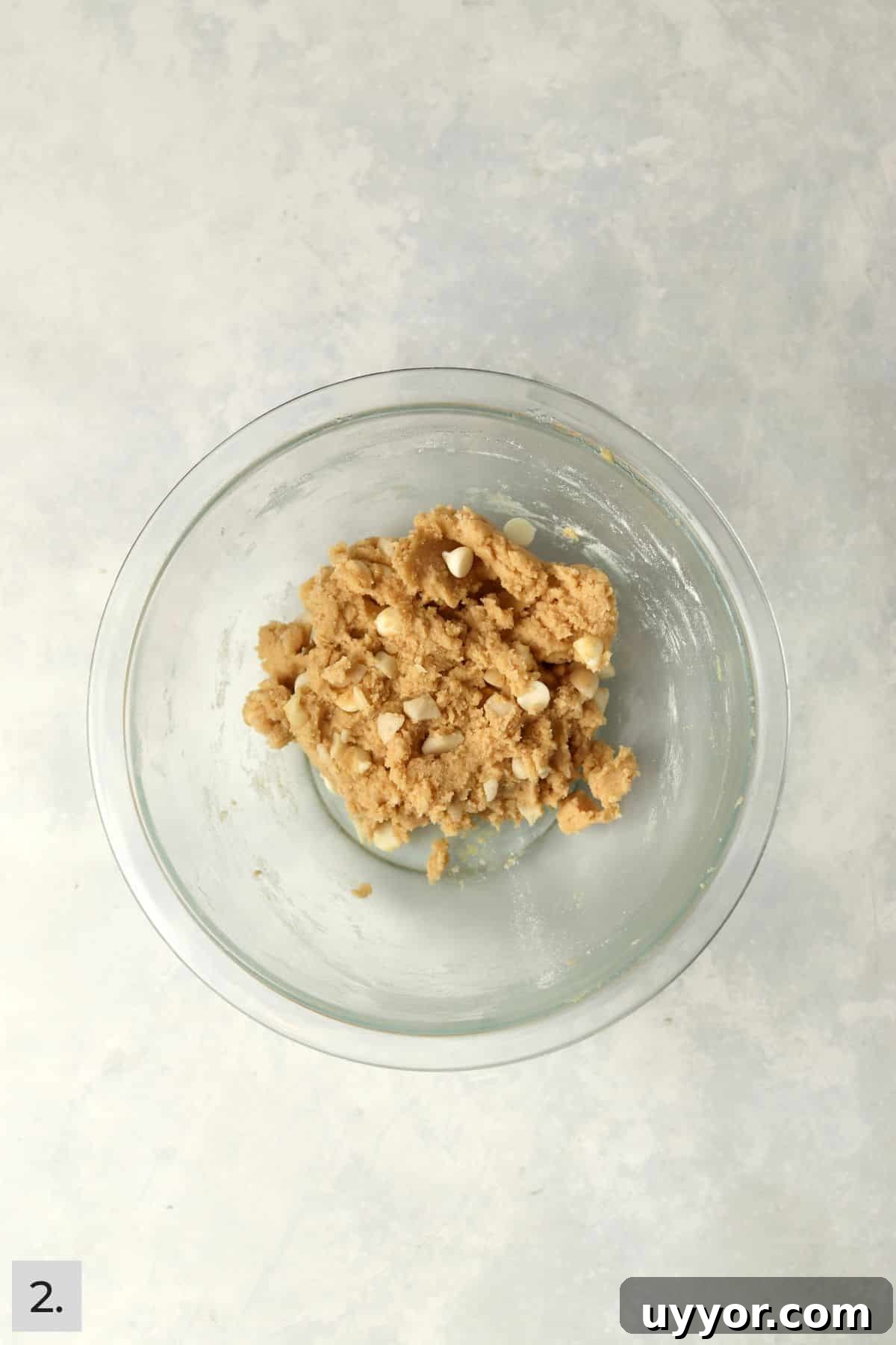 Small batch of white chocolate macadamia nut cookie dough in a mixing bowl.