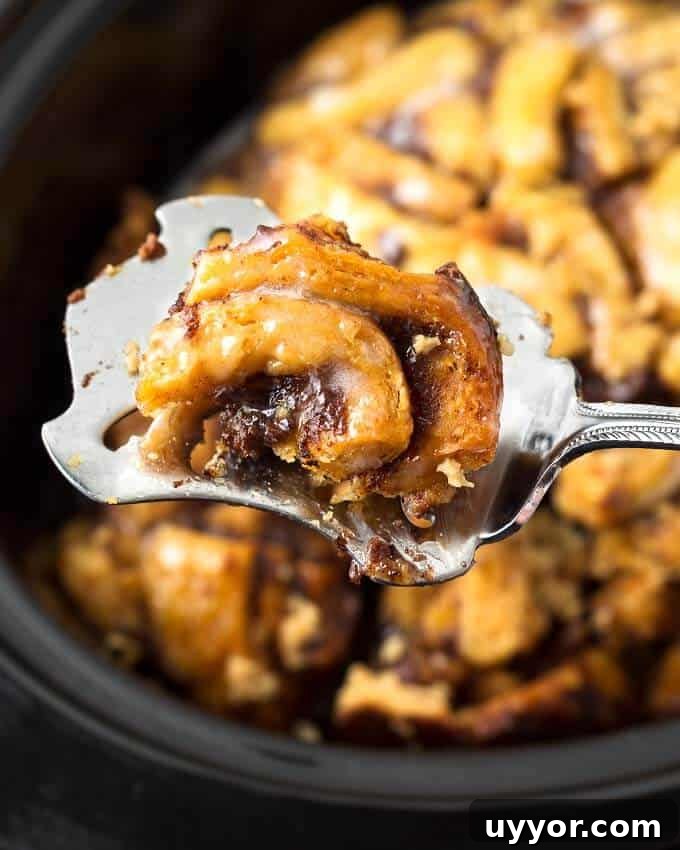Crockpot Cinnamon Roll Casserole: Gooey Breakfast Baking Recipe 7 Close up of spoonful of Slow Cooker Cinnamon Roll Casserole
