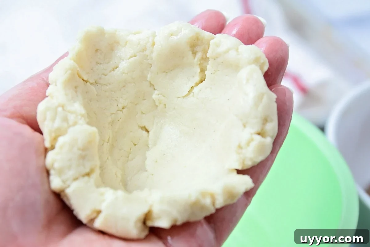 Pupusas dough cupped together in hands.