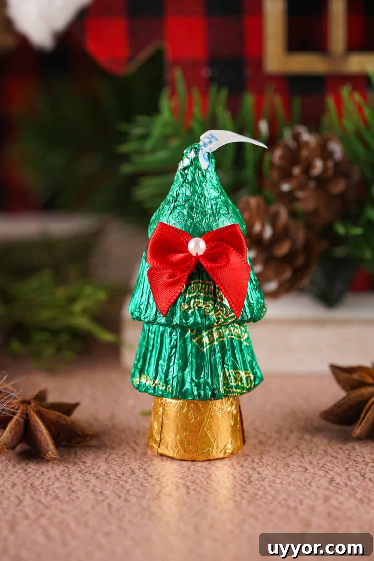 These Reese's Peanut Butter Cup Christmas Trees are so fun and easy to make. Candy Christmas trees using Reese's peanut butter cups, Rolos and Hershey Kisses