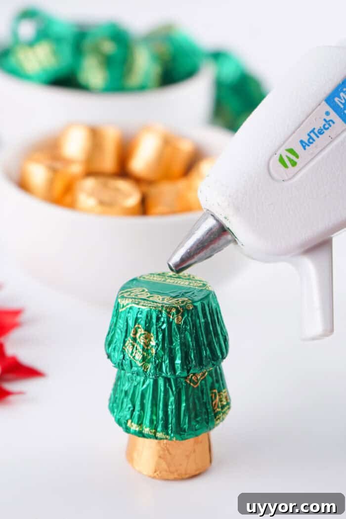These Reese's Peanut Butter Cup Christmas Trees are so fun and easy to make. gluing the mini Reese's candies together