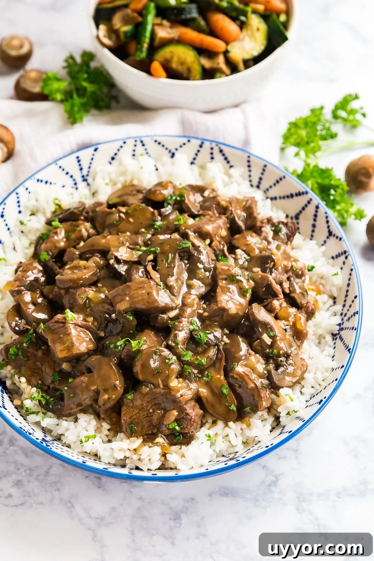 Instant Pot Beef Tips with Rich Mushroom Gravy 9 A bowl of beef tips and mushrooms over rice.