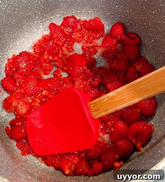 Classic Depression-Era Water Pie Recipe You Can Make Today 8 Fresh Raspberries in a small sauce pan being smashed for raspberry sauce.
