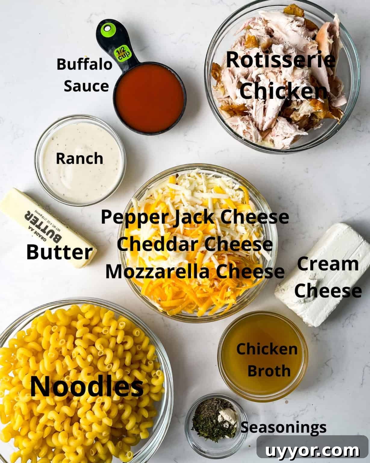 ingredients to make buffalo mac and cheese - chicken, buffalo sauce, ranch dressing, cheese, seasonings, butter, and noodles.