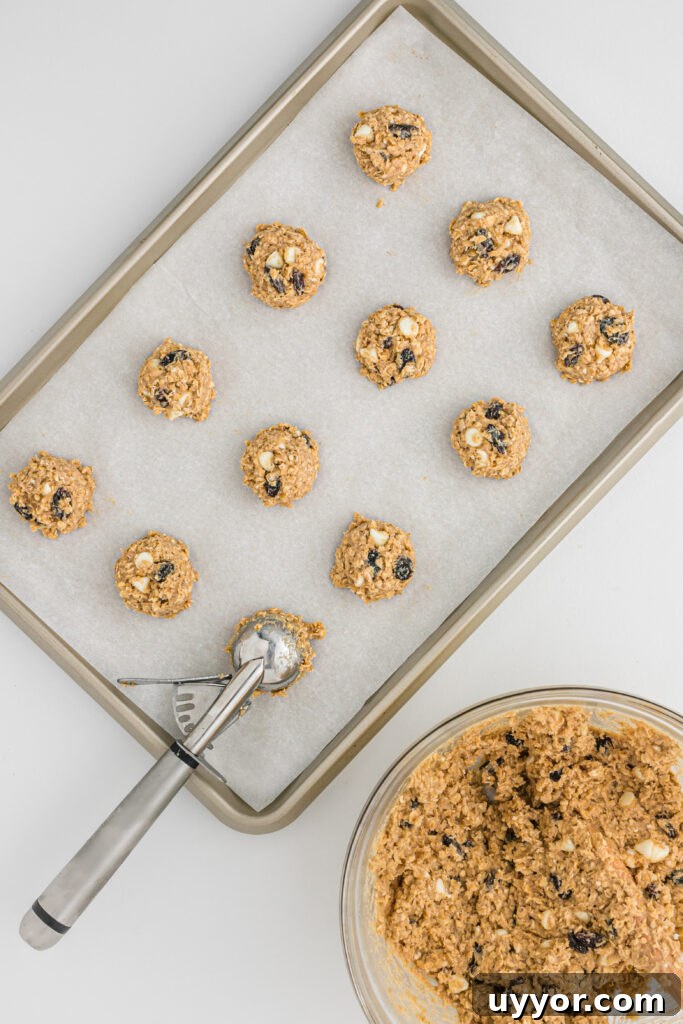 Soft pumpkin cookies with white chocolate chips on a baking sheet.