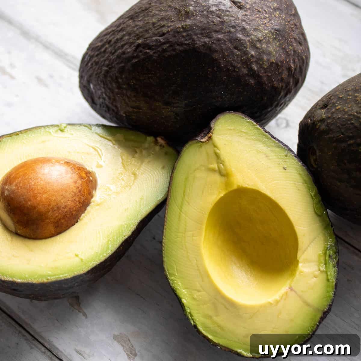 75 Foods That Start With A: Complete A-to-Z List of A Foods 3 Half and whole avocado on a table.