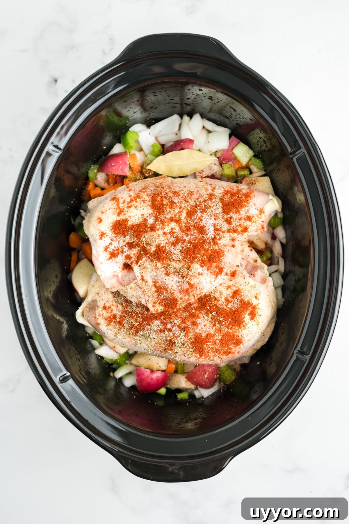 Chicken and seasonings added on top of the vegetables. 