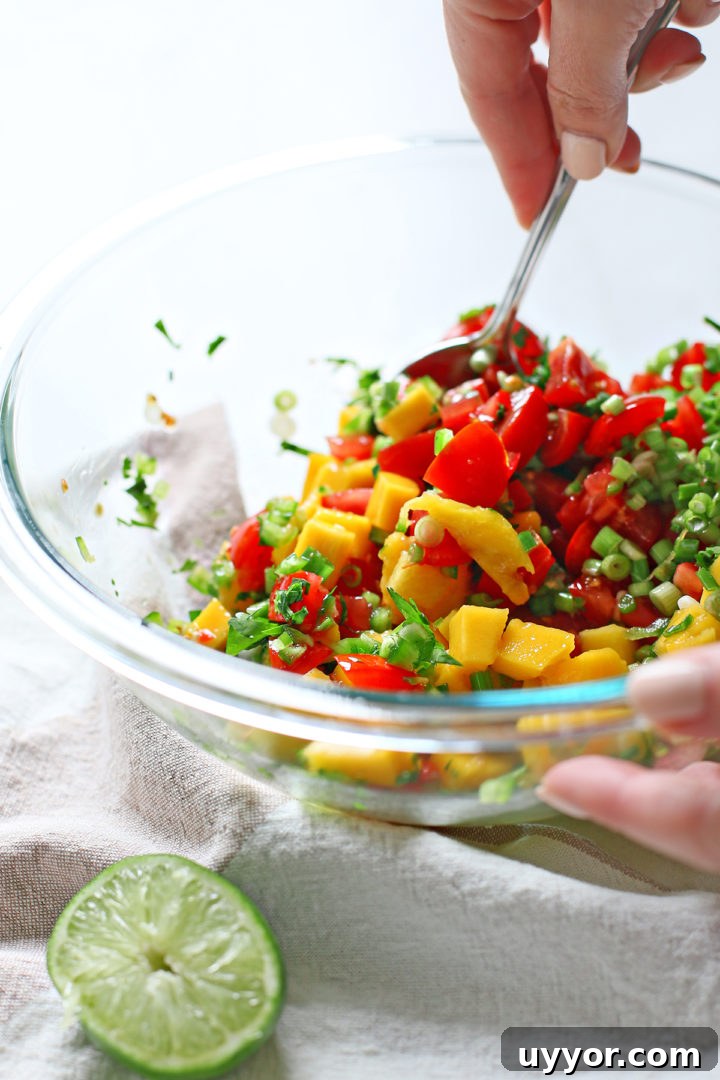 Fresh Mango and Tomato Salsa Recipe for Summer Parties 4 woman stirring a bowl of ingredients to make mango salsa with tomatoes