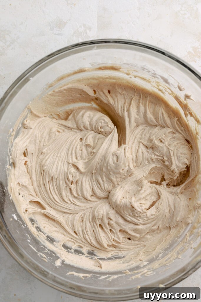Moist Pumpkin Olive Oil Cake with Cinnamon Glaze 13 A glass bowl with cinnamon cream cheese frosting in it.