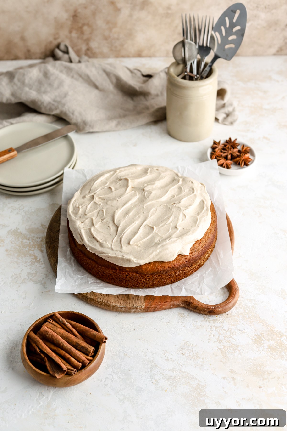 Moist Pumpkin Olive Oil Cake with Cinnamon Glaze 15 Pumpkin cake with frosting, some plates and some cinnamon sticks.