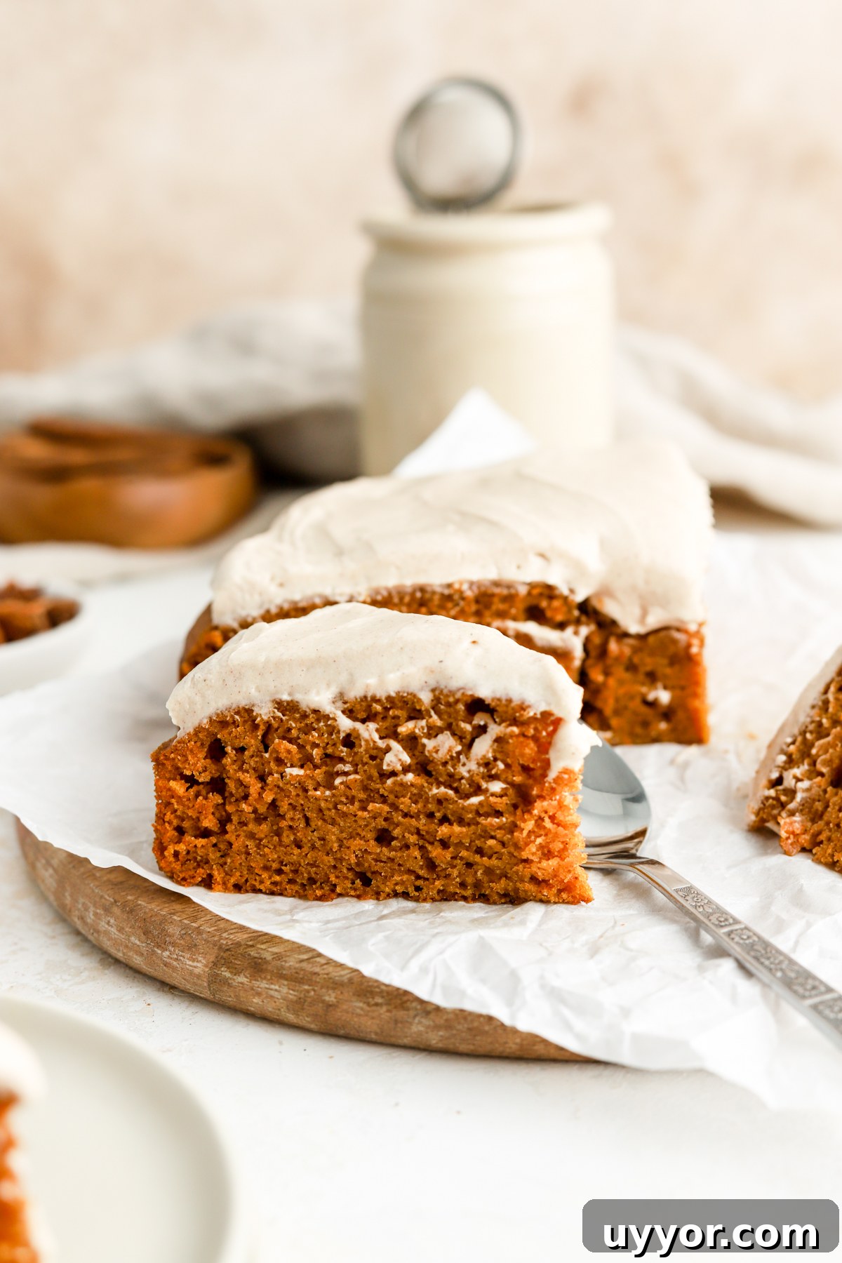 Moist Pumpkin Olive Oil Cake with Cinnamon Glaze 16 A slice of pumpkin cake with frosting and a spoon.