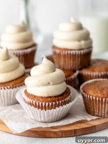 Carrot cake cupcakes with frosting swirled on top.