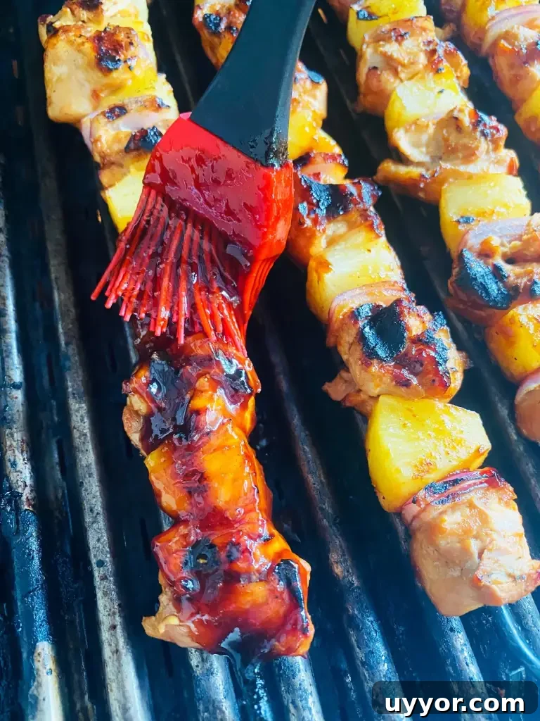 Hawaiian BBQ Chicken Skewers with Pineapple Glaze 6 brushing the Grilled Hawaiian BBQ Chicken Skewers with sauce