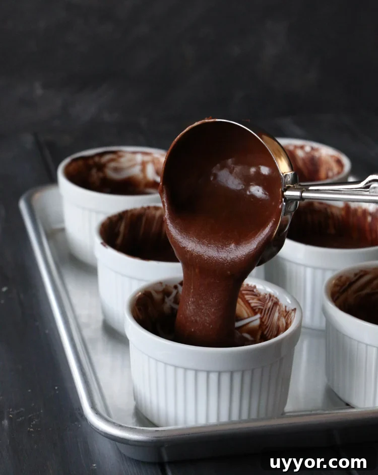 Spicy Chocolate Lava Cakes with Molten Centers 12 scooping spicy molten chocolate lava cake batter into white ramekins