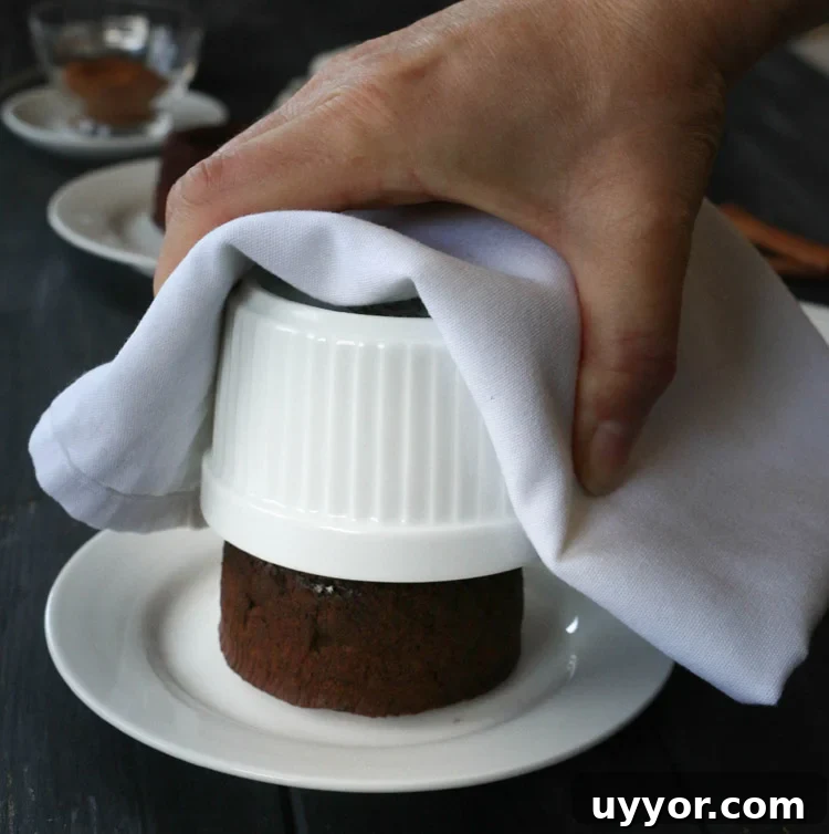 Spicy Chocolate Lava Cakes with Molten Centers 13 Lifting ramekin up from a chocolate lava cake