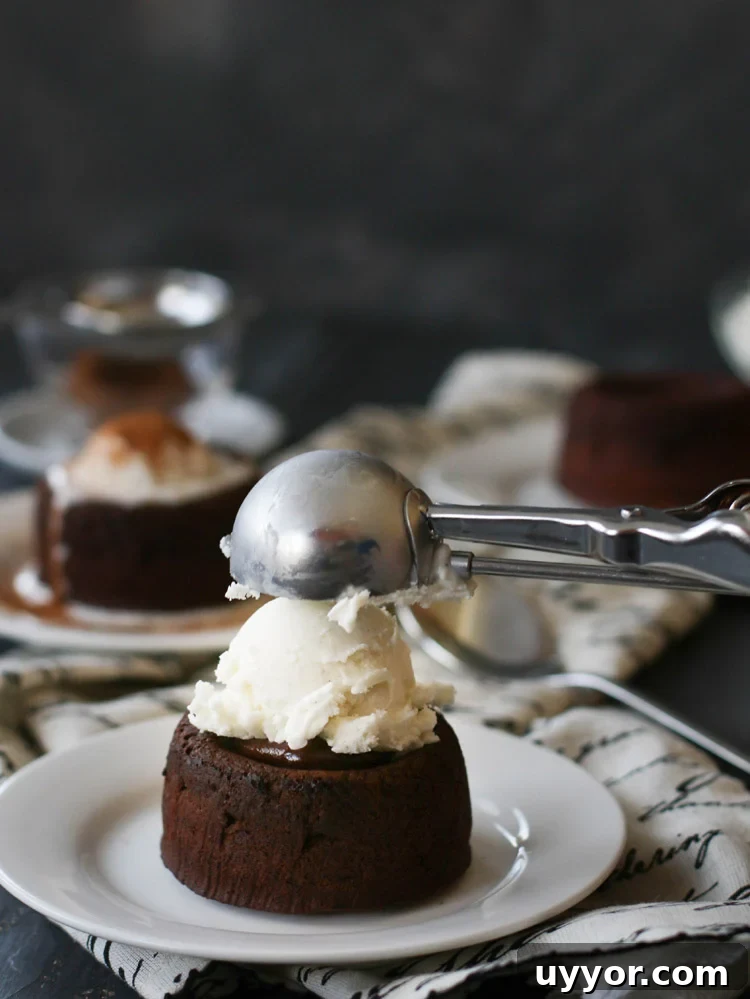 Spicy Chocolate Lava Cakes with Molten Centers 14 a scoop of vanilla ice cream being placed on top of a Spicy Molten Chocolate Lava Cake