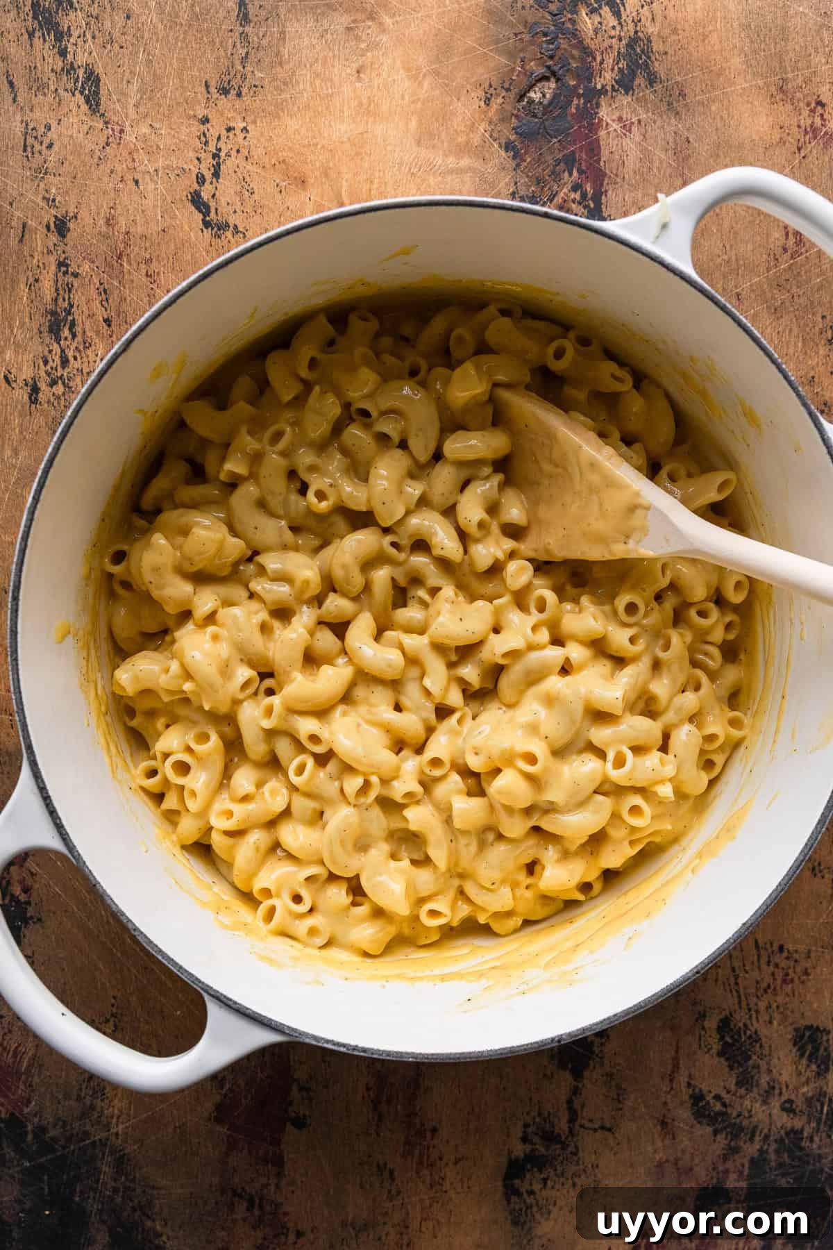 Mixing the cooked macaroni with cheese sauce.