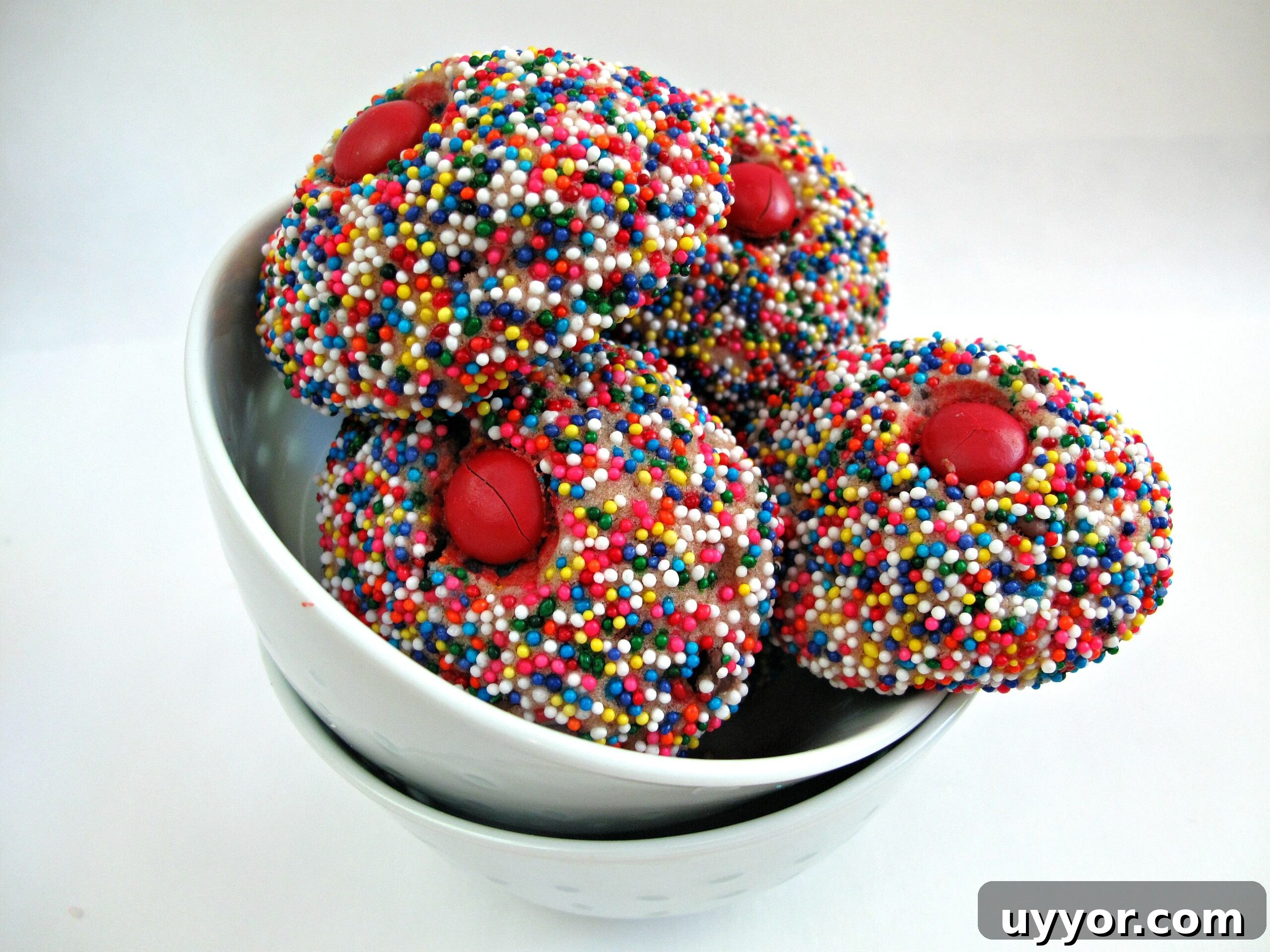 Melted Ice Cream Cookies- dense but tender balls of slightly sweet cookie, mildly flavored by the ice cream and chips of your choice. With a red M&M on top. Round cookies covered in multicolored nonpareils and a red candy on top like ice cream scoops.