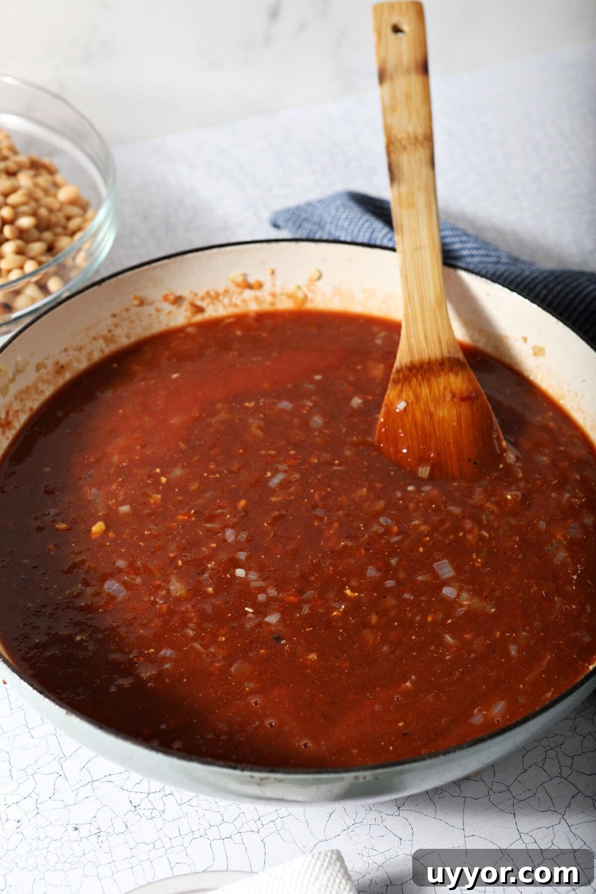 Baked bean sauce in a pan with a wooden spoon