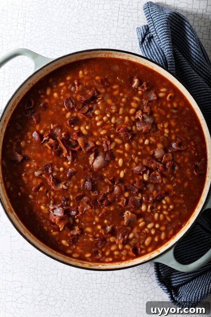 Close up of a pot of beans with sauce before baking in the oven