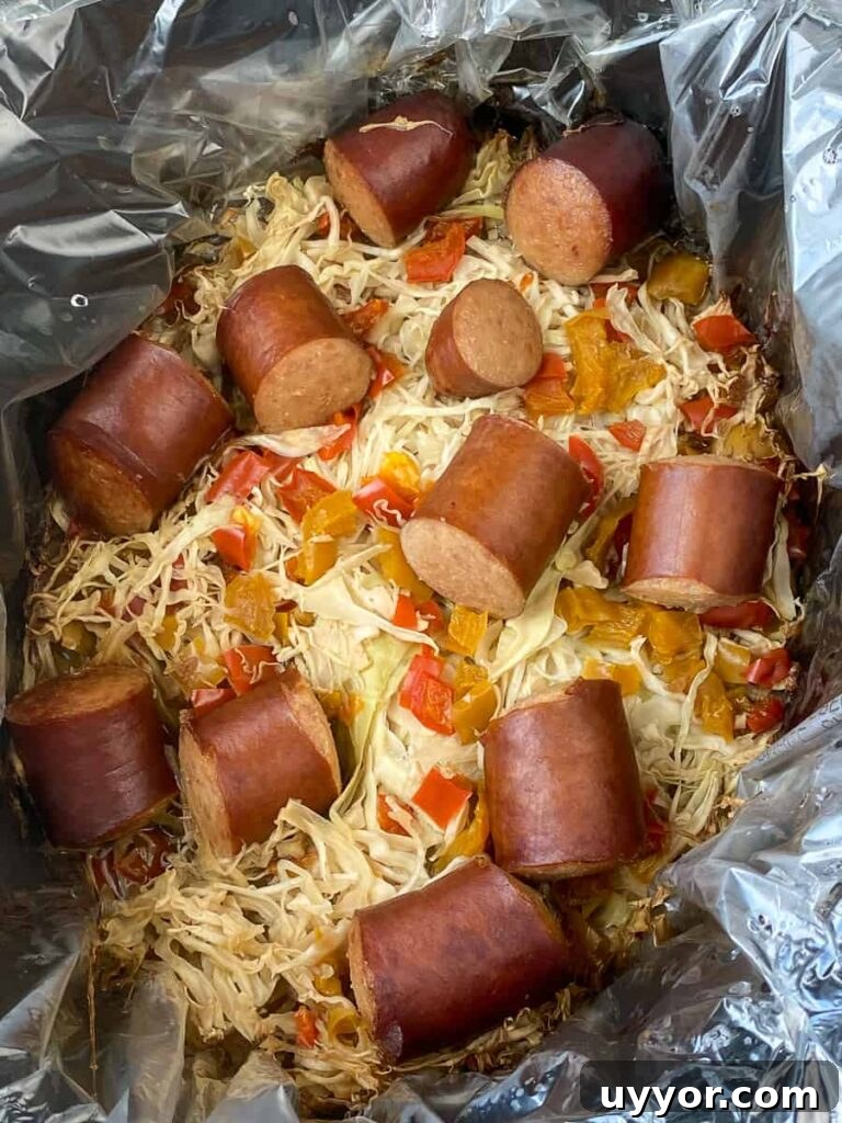 Savory Kielbasa and Cabbage Skillet Recipe for Weeknight Dinners 12 Cooked chunks of Kielbasa and cabbage in a crock pot with liner