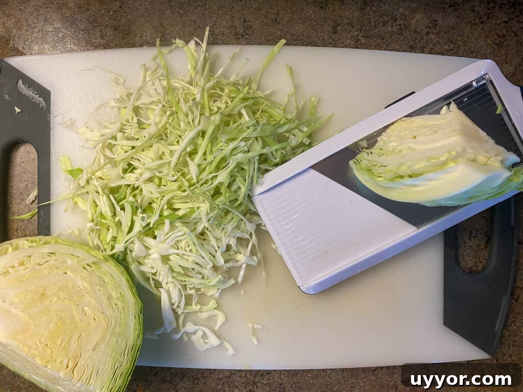 Savory Kielbasa and Cabbage Skillet Recipe for Weeknight Dinners 8 Head of cabbage and shredded cabbage on cutting board by mandoline