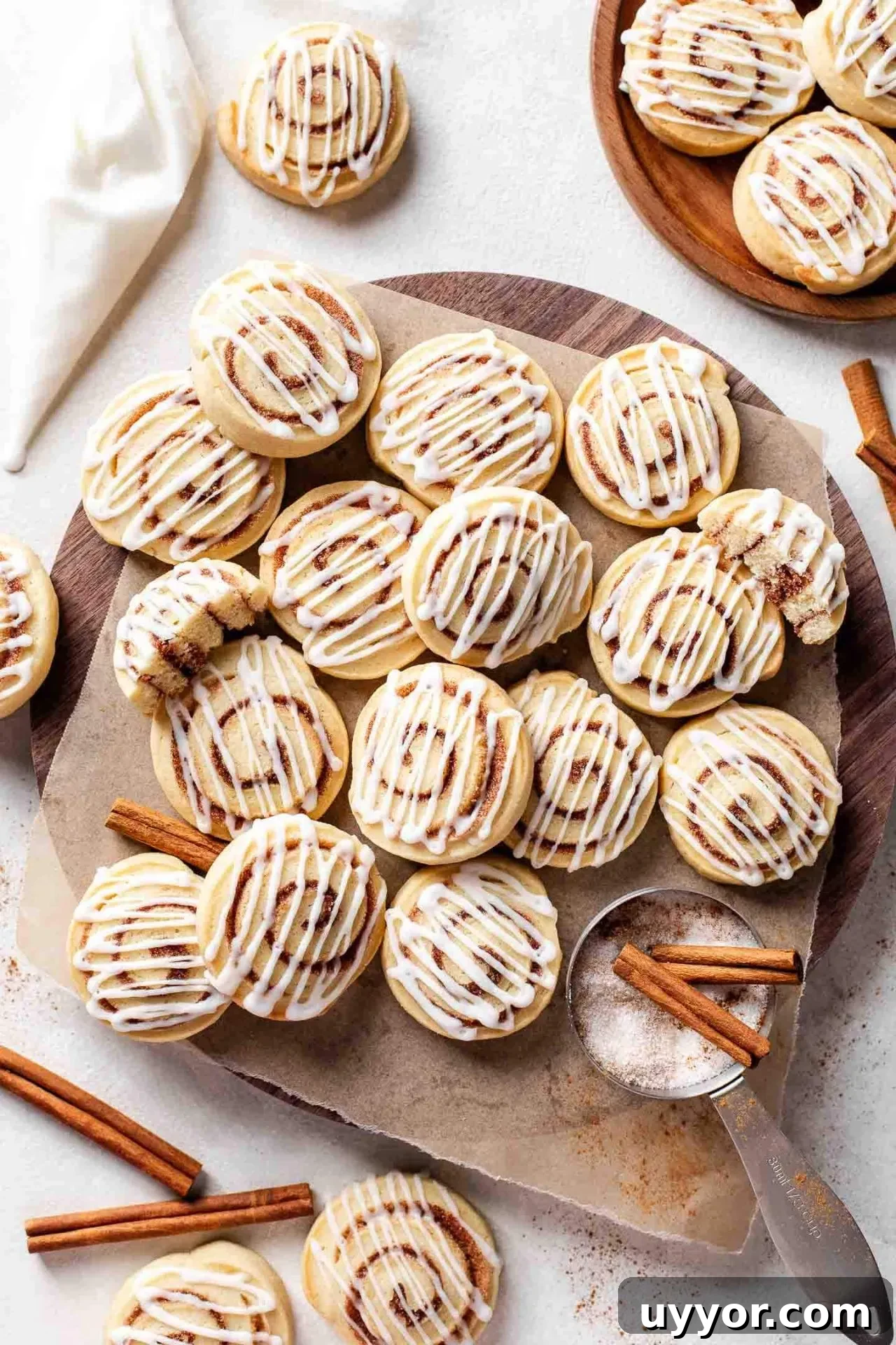 Cinnamon Roll Cookie Recipe: Soft Swirls with Cream Cheese Glaze 3 iced cinnamon roll cookies on parchment lined board