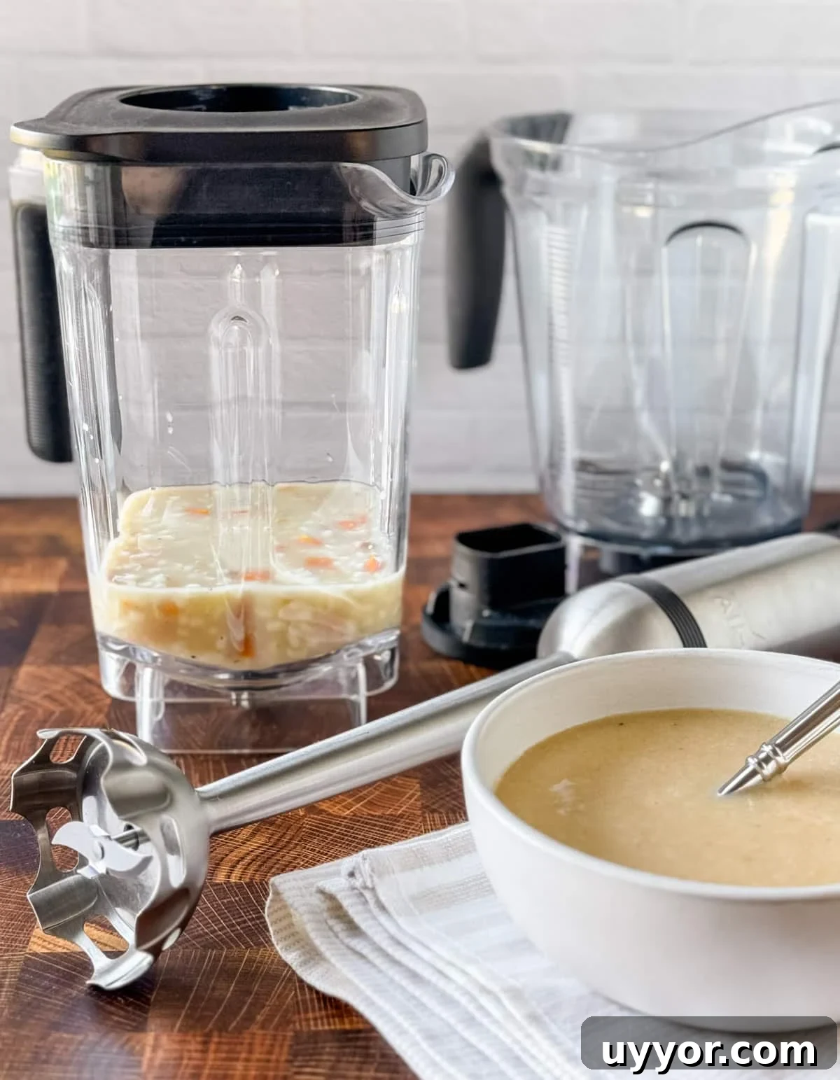 How to Safely Blend Hot Soups and Liquids Without Splashes 2 two blender jars, a stick blender, and a bowl of cream of chicken soup on a butcher block counter
