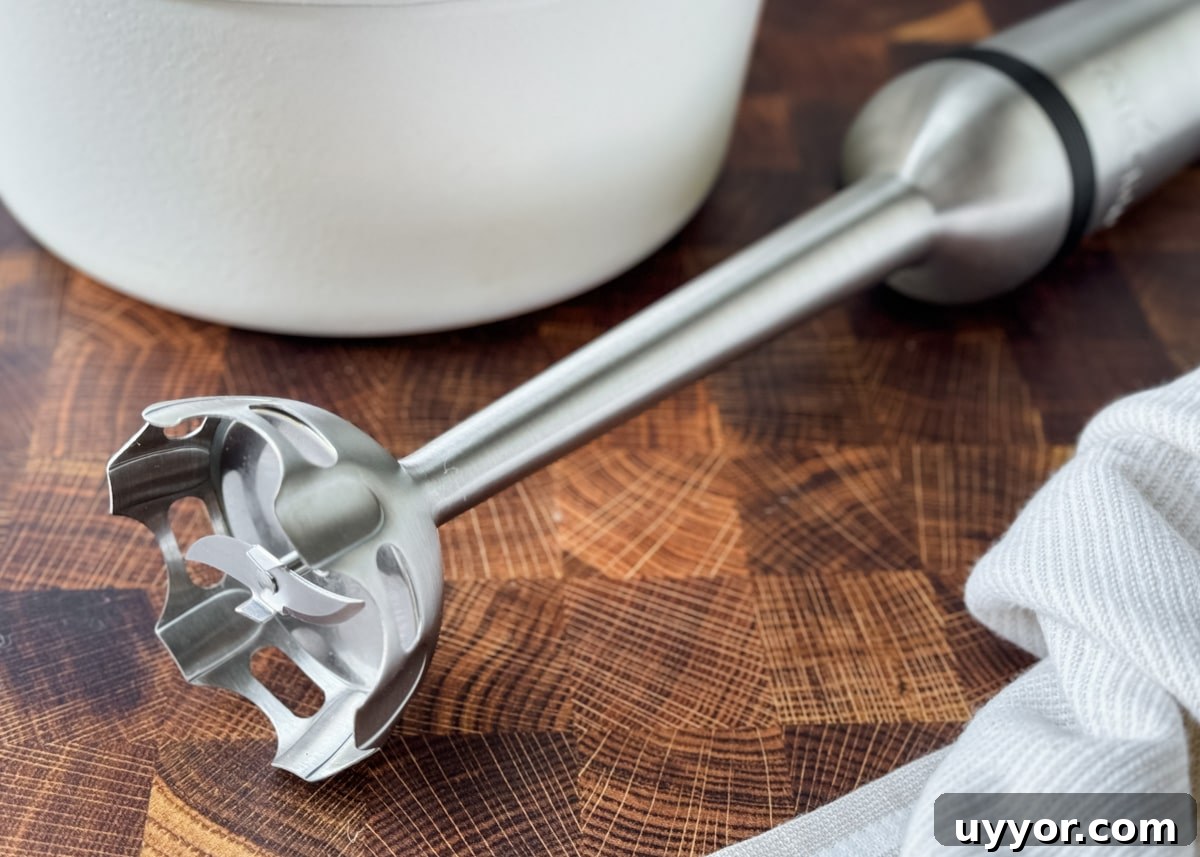 How to Safely Blend Hot Soups and Liquids Without Splashes 4 closeup of an all clad immersion blender on a butcher block counter