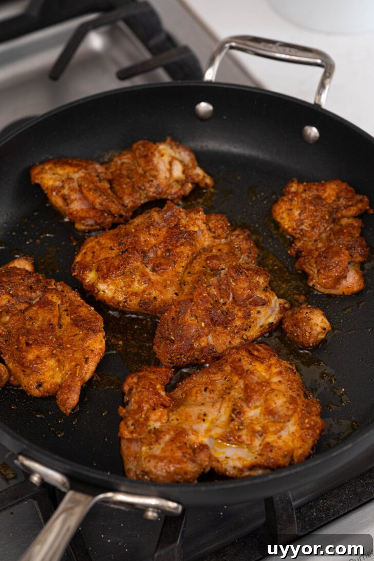 Cheesy Chicken Empanadas with Homemade Savory Filling 3 Sazon seasoned chicken frying in a pan.